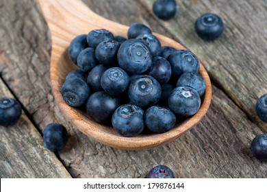 fresh blueberries in a wooden spoon over wooden table - Powered by Shutterstock