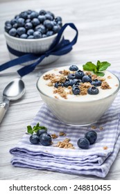Fresh blueberry yogurt with granola and mint on a background - Shutterstock ID 248810455