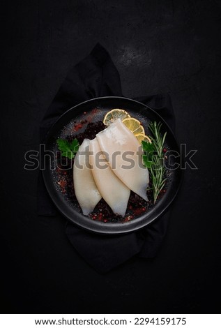 Fresh body, squid, raw, three carcasses, top view, no people, on a plate,