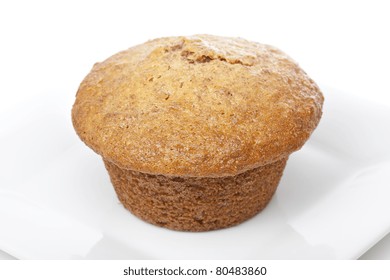 A Fresh Bran Muffin Against A White Background