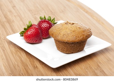 A Fresh Bran Muffin Against A White Background