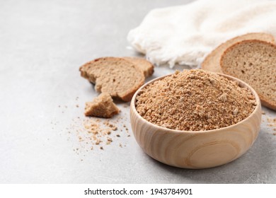 Fresh bread crumbs in bowl on grey table