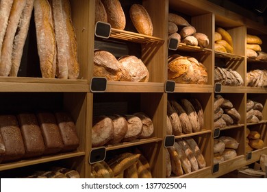 Fresh bread on shelves in a bakery, city market, different types of freshly baked bread - Powered by Shutterstock