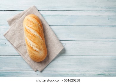 Fresh bread on wooden table. Top view with space for your text - Shutterstock ID 551620258