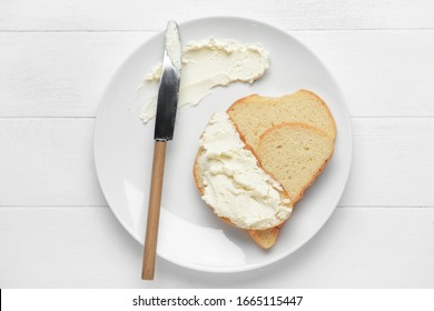 Fresh Bread With Tasty Cream Cheese And Knife On Plate