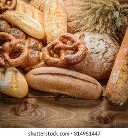frisches Brot und Weizen auf Holz