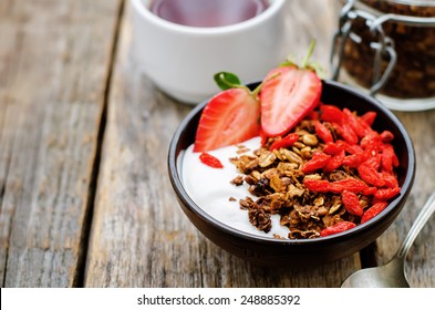 fresh breakfast of granola, yogurt, nuts, goji berries and strawberries. tinting. selective focus - Powered by Shutterstock