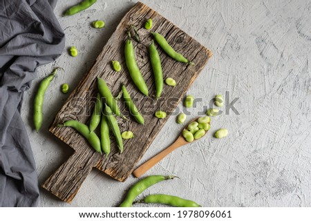Fresh broad beans with pod on rustic background, healthy food