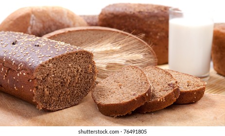 Fresh brown bread with a glass of milk - Shutterstock ID 76491805