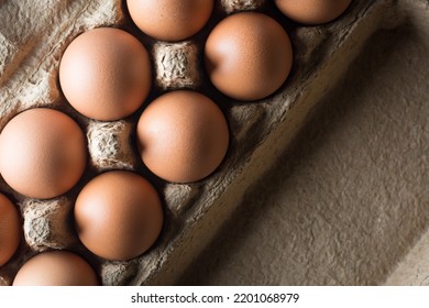 Fresh Brown Chicken Eggs In An Egg Box, Taken Straight From Above With Space For Text And Dramatic Lighting, Healthy Organic Food Concept