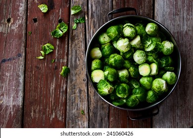 Fresh brussel sprouts over rustic wooden texture. Top view.