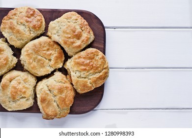 Fresh buttermilk southern biscuits or scones over a white table shot from above. Top view.