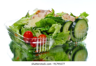Fresh Caesar salad in a take out container with reflection
