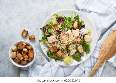 Fresh Caesar Salad In White Plate On  Concrete Table. Top View.