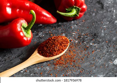 Fresh Capia peppers and chili flakes or powder in wooden spoon on grey rustic table, healthy turkish spice - Powered by Shutterstock