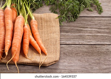 Fresh carrot with green leaves on jute bag