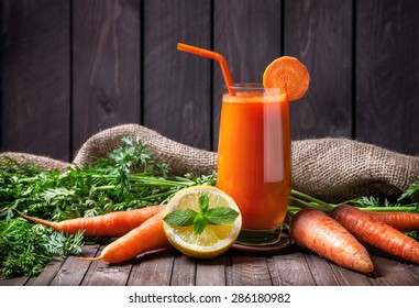 Fresh Carrot Juice With Lemon And Mint On Wooden Background