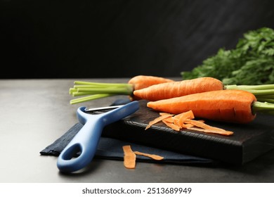 Fresh carrots, vegetable peeler and peels on gray textured table, closeup - Powered by Shutterstock