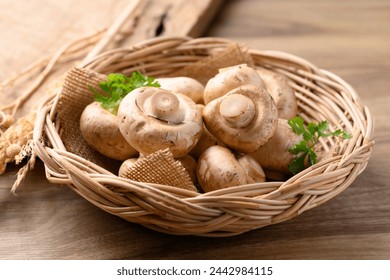 Fresh Champignon mushroom in natural basket on wooden background - Powered by Shutterstock