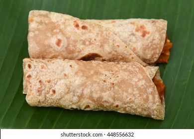 Fresh chapati roll, chapathi, rotii or unleavened flatbread made from whole wheat flour/ atta and  hot and spicy egg roast curry, Popular traditional North Indian food homemade. Mumbai India.
