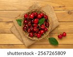 Fresh cherries in bowl on wooden background, top view