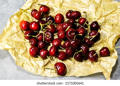 Fresh Cherry Fruit In Crash Paper On Wooden Table