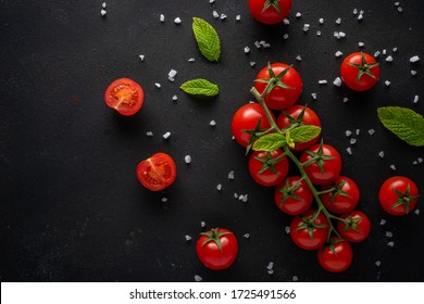 Fresh Cherry Tomatoes On A Black Background With Spices.  Food Background. Top View.