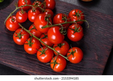 Fresh cherry tomatoes on a black background with spices. Food background