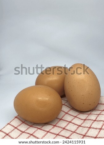 Fresh chicken eggs. Eggs served on a wooden coaster with copy space. Selective focus image.