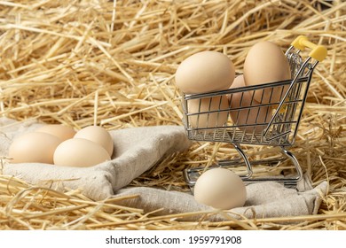 Fresh chicken eggs in straw on a mini shopping cart. Online delivery concept for farm organic eggs. Copy space.