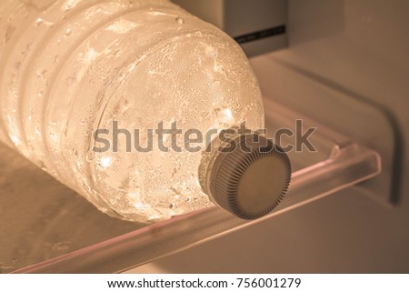 Fresh and Chilled Bottles of Drinking Water in the refrigerator with shelves for where to place bottles of water, food with copy space