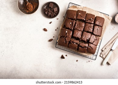 Fresh chocolate brownies on white. Delicious homemade chocolate dessert, pie brownie and ingredients, top view, copy space.