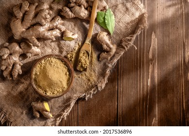 Fresh chopped ginger root and ground ginger powder in wooden spoon