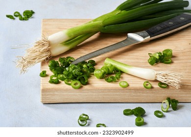 Fresh chopped green onions on a wooden cutting board. Close up - Powered by Shutterstock