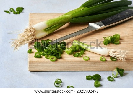 Fresh chopped green onions on a wooden cutting board. Close up