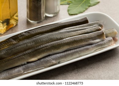 Fresh cleaned raw eels on a dish ready to cook