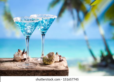 Fresh cocktail with blue curacao on beach background