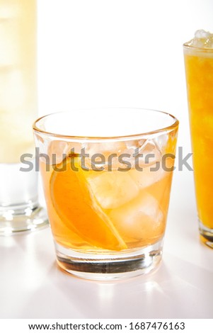 Fresh cocktail with orange and ice. White background