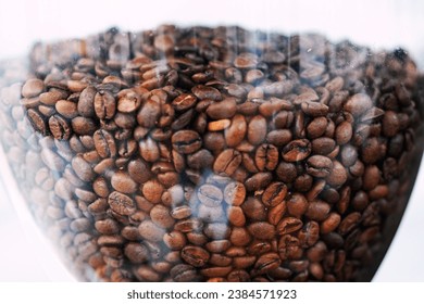 Fresh Coffee beans in an electric commercial coffee grinder. close-up - Powered by Shutterstock