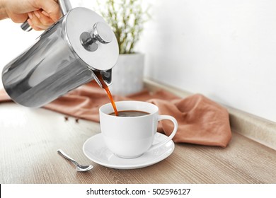 Fresh coffee pouring from pot into cup - Powered by Shutterstock