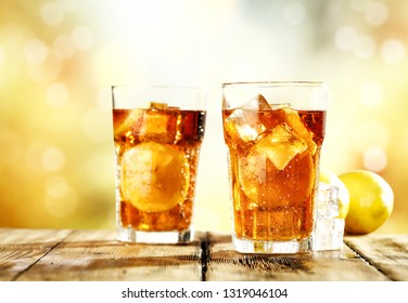 Fresh cold ice tea and summer blurred orange background. Free space for your decoration. 
