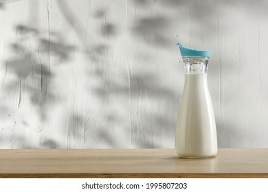 Fresh cold milk on desk and wall with shadows 