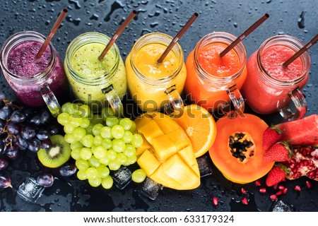 Fresh Color Juices Smoothie Violet Green Yellow Orange Red from Tropical Fruits Kiwi Water Melon Strawberry Apple Orange Banana Pine Apple Mango Pomegranate Grape Bottles Rainbow Dark Background