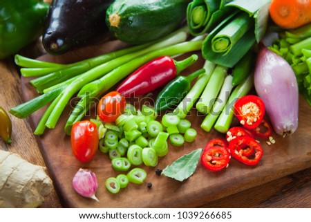 Fresh colorful Vegetable ingredient board - aubergine, courgette, leek, carrot, onion, spring onions, chive, shallot, tomato, celery,  bell pepper, chili pepper, ginger, garlic, bay leaves, peppercorn