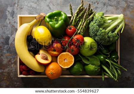 Fresh and colorful vegetables and fruits in a wooden crate