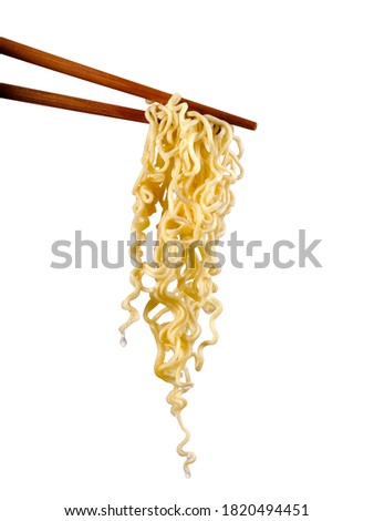 Fresh cooked noodles between two Chinese chopsticks, close up