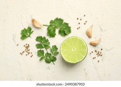 Fresh coriander leaves, dried seeds, garlic and lime on light textured table, flat lay - Powered by Shutterstock