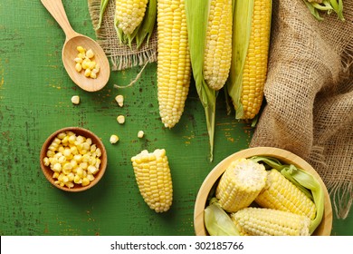 Fresh Corn On Cobs On Green Wooden Table, Top View