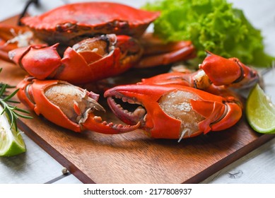 fresh crab on wooden board, claw crab cooking food seafood plate with herbs spices lemon lime salad, boiled or steamed crab red in the restaurant