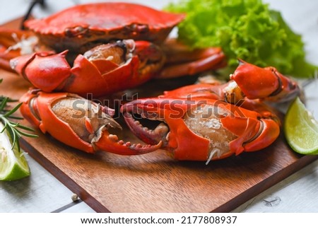 fresh crab on wooden board, claw crab cooking food seafood plate with herbs spices lemon lime salad, boiled or steamed crab red in the restaurant